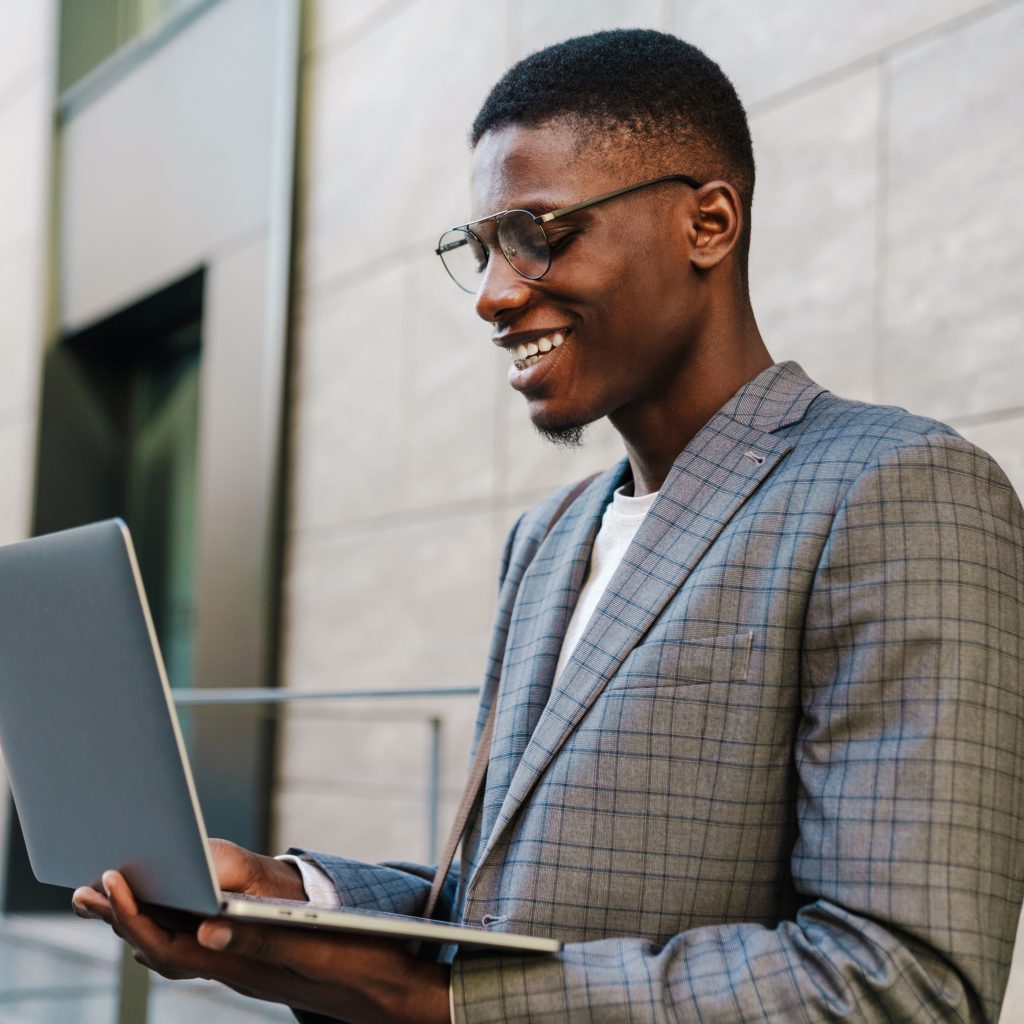 Black guy surfing his LinkedIn Account using his laptop